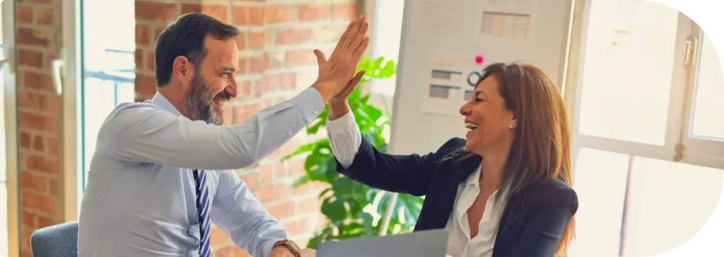 Empresário dono de uma transportadora dando high five em um dos consultores da LR ao fechar um projeto de ISO9001