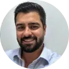 Ricardo, fundador da LR Soluções Empresariais, aparece na foto sorrindo, a foto enquadra bem o seu rosto, ele possui cabelos pretos e barba cheia.
